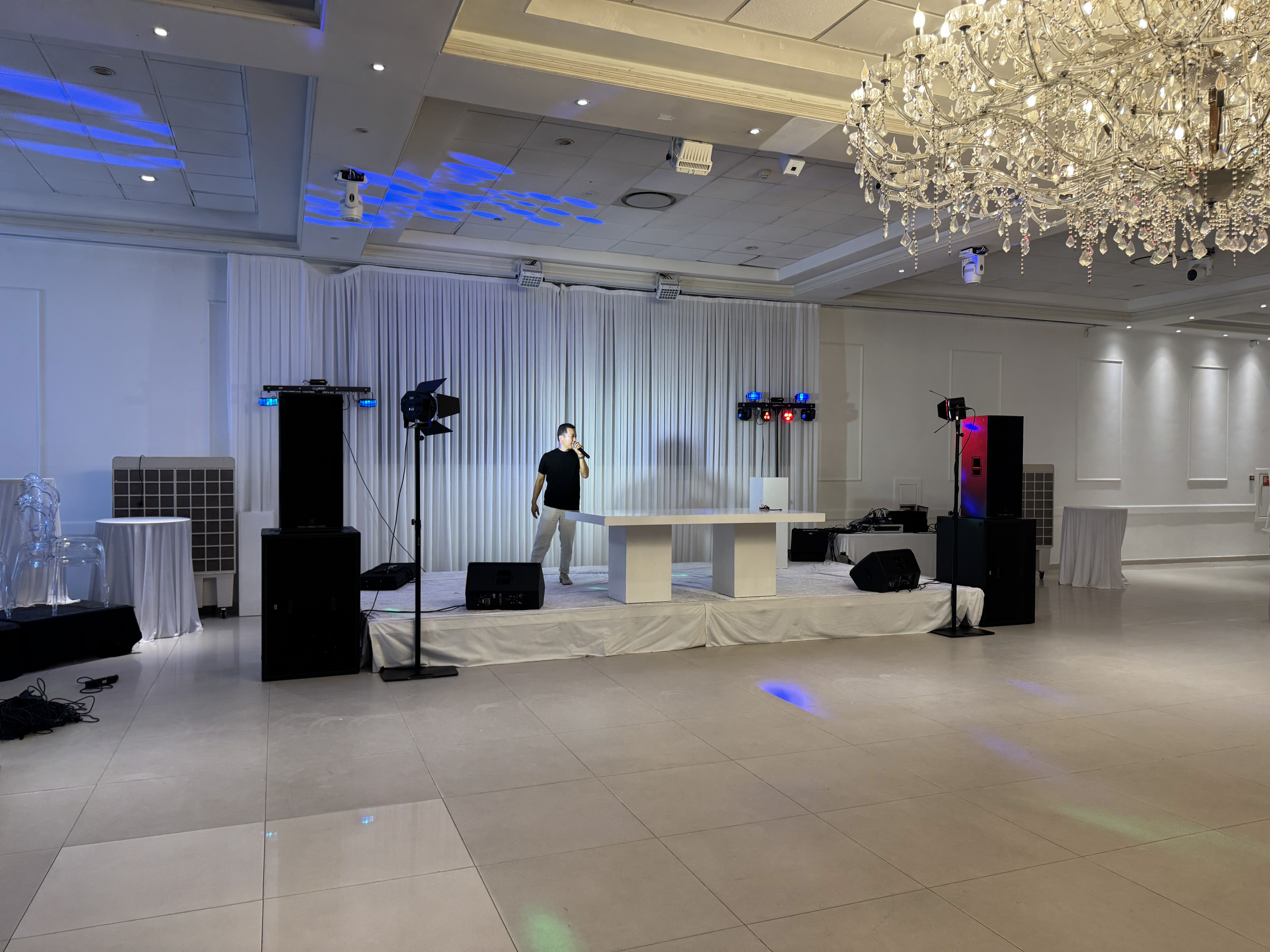 Maatwerk DJ-productie met witte DJ-booth, podium, speakers en licht